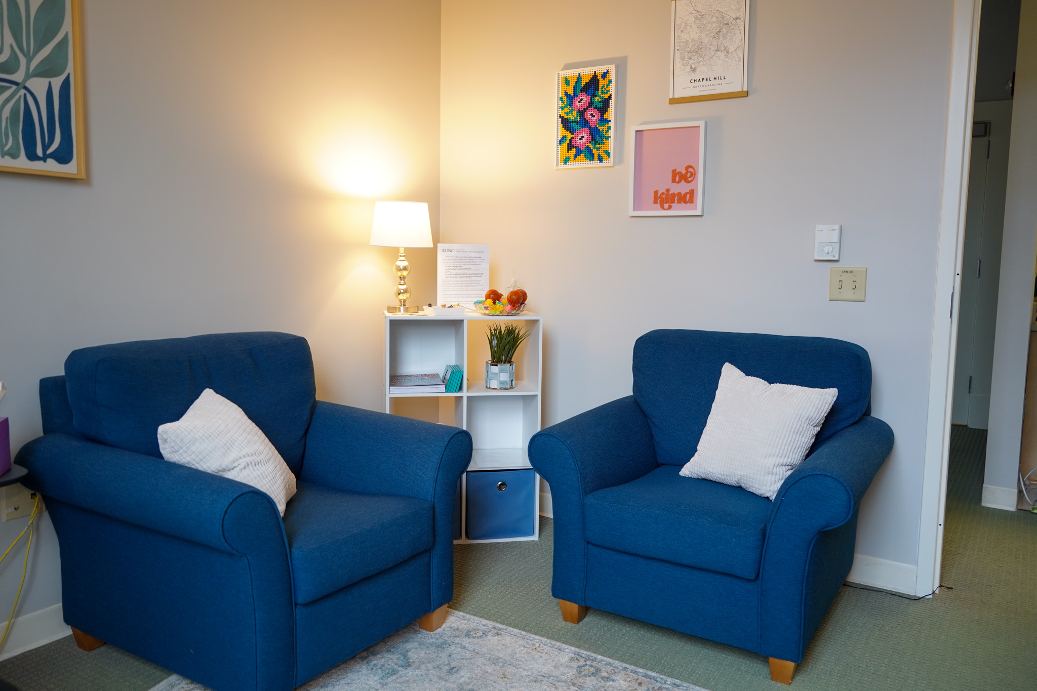 Office with two chairs, a bookshelf, and decor.